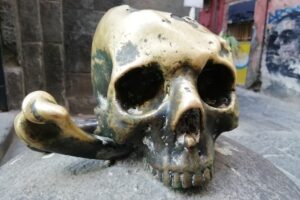 Colonne de pierre surmontée d’une tête de mort en bronze à Naples